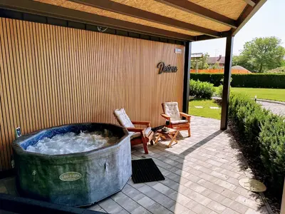 a hot tub on a patio with two chairs at DESIREE with Sauna&HotTube at Potatoland Lux Resort in Šenčur