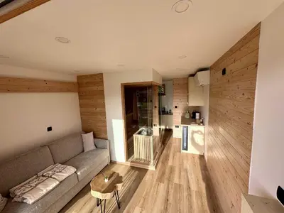 a living room with a couch and a kitchen at DESIREE with Sauna&HotTube at Potatoland Lux Resort in Šenčur