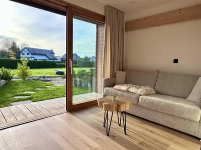 a living room with a couch and a large window at DESIREE with Sauna&HotTube at Potatoland Lux Resort in Šenčur
