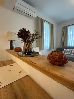 a table with a vase of flowers on top of it at Bella Mura Nature Apartment Lipa 109 in Podčetrtek