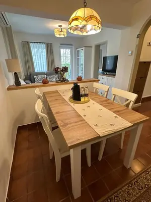 a dining room with a wooden table and chairs at Bella Mura Nature Apartment Lipa 109 in Podčetrtek