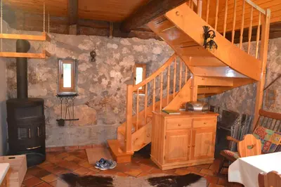 a room with a wooden staircase and a wood stove at House Pod Lipo in Trenta