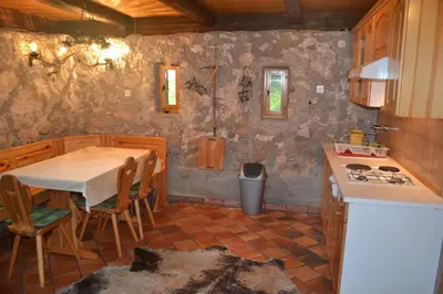 a kitchen with a table and a sink and a stove at House Pod Lipo in Trenta