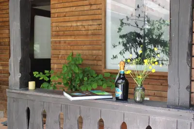 a table with a bottle of wine and a book at Unique Forest Lodge Bled in Bled