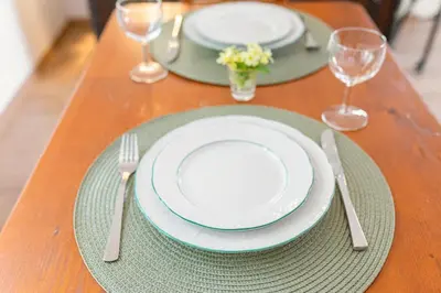 a table with plates and silverware on a wooden table at Unique Forest Lodge Bled in Bled