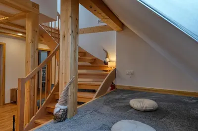 an attic room with stairs and a room with a pillow at Domačija Kveder in Cerklje na Gorenjskem