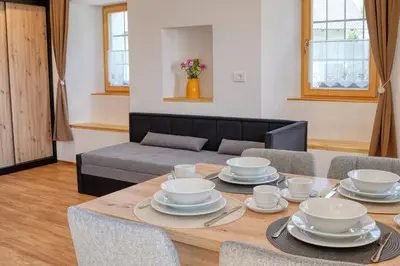 a dining room with a table with dishes on it at Domačija Kveder in Cerklje na Gorenjskem