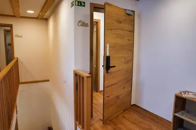 a wooden door in a room with a staircase at Domačija Kveder in Cerklje na Gorenjskem
