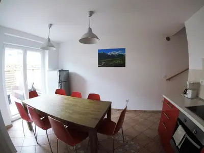a kitchen with a wooden table and red chairs at Apartment Wild Soca No 7 in Bovec