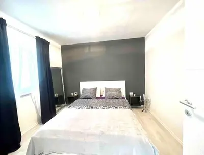 a bedroom with a large bed in a black wall at Apartment Lucija - Dekani in Dekani