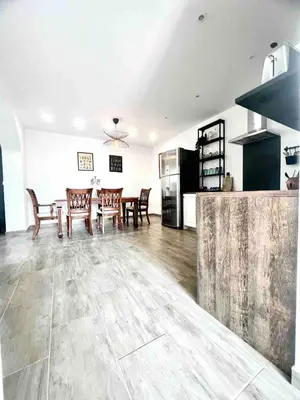 a living room with a table and chairs and a kitchen at Apartment Lucija - Dekani in Dekani