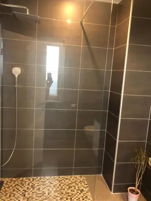 a bathroom with a shower with gray tiles at Apartment Lucija - Dekani in Dekani