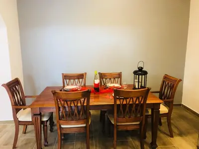a dining room table with chairs and a bottle of wine at Apartment Lucija - Dekani in Dekani