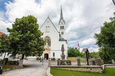 a white church with a steeple on top of it at Old Parish House in Bled