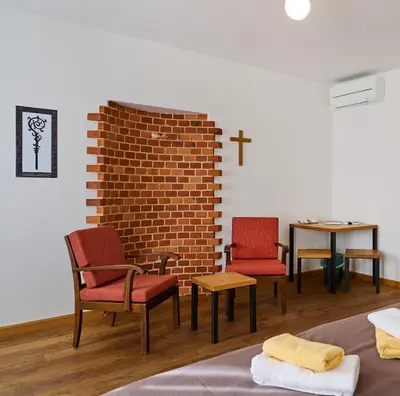 a room with two chairs and a brick wall at Old Parish House in Bled