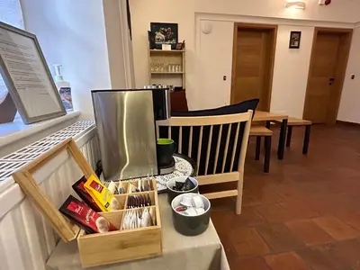 a room with a table and chairs and a counter with food at Old Parish House in Bled