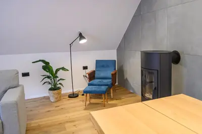 a living room with a chair and a fireplace at Grannys Retreat in Žiri
