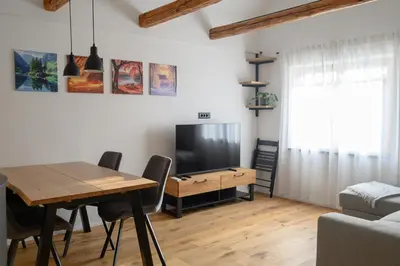 a living room with a dining room table and a television at Grannys Retreat in Žiri