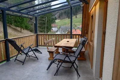 a patio with a wooden table and chairs on a balcony at Grannys Retreat in Žiri