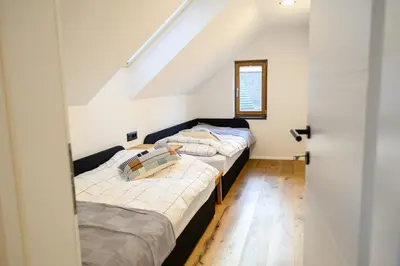 two beds in a room with a attic at Grannys Retreat in Žiri