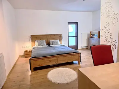 a bedroom with a bed and a red chair at Šipk -FREE-PARKING-BREAKFAST-TERRACE in Vojnik