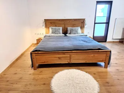 a bedroom with a large wooden bed with a rug at Šipk -FREE-PARKING-BREAKFAST-TERRACE in Vojnik