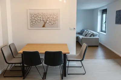 a dining room with a table and chairs and a couch at Modern & Cozy Apartment Jesenice in Jesenice
