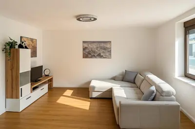 a white living room with a couch and a tv at Modern & Cozy Apartment Jesenice in Jesenice