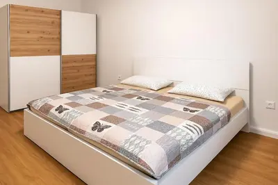 a bedroom with a bed with a quilt on it at Modern & Cozy Apartment Jesenice in Jesenice