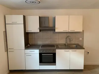 a kitchen with white cabinets and a sink at Modern & Cozy Apartment Jesenice in Jesenice