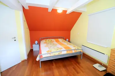 a bed in a room with an orange wall at BledRoom in Bled