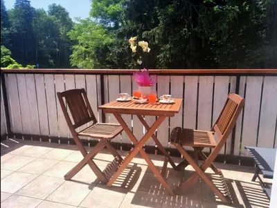 a wooden table and two chairs on a patio at BledRoom in Bled