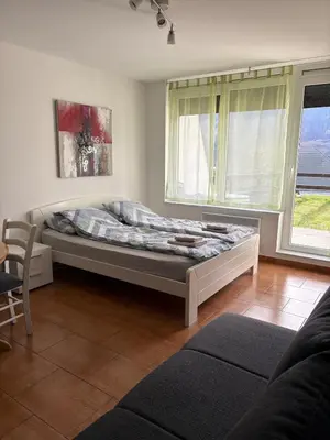 a bedroom with a bed in a room with windows at Stefs Garden in Bovec