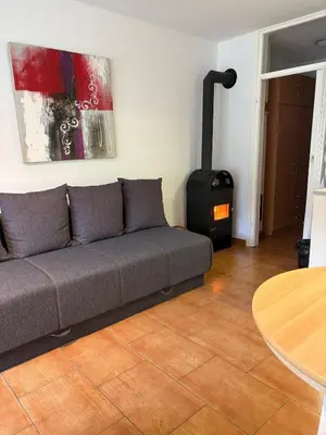 a living room with a couch and a wood stove at Stefs Garden in Bovec