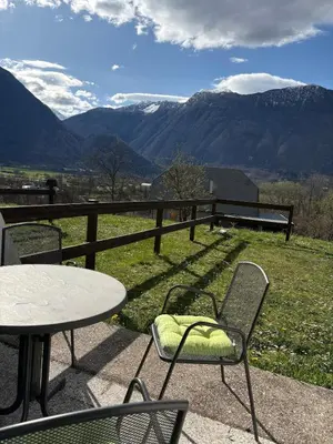 a table and chairs on a patio with a view of mountains at Stefs Garden in Bovec