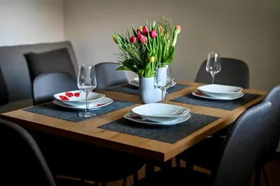a wooden table with plates and a vase of flowers at Countryside house in Male Brusnice
