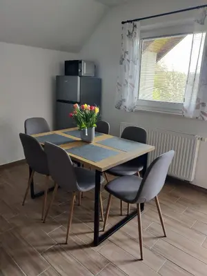 a dining room table with chairs and a vase of flowers on it at Countryside house in Male Brusnice