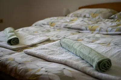 an unmade bed with towels on top of it at Countryside house in Male Brusnice