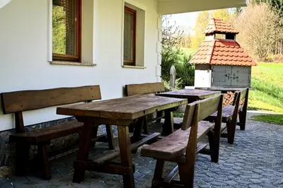 a wooden table and benches on a patio at Countryside house in Male Brusnice