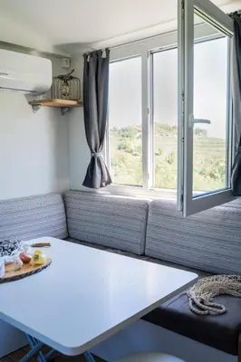 a living room with a table and a window at Panoramablick 360 Grad in den Weinbergen in Tržec