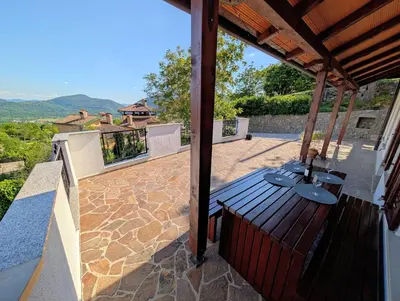 a patio with a wooden deck with a view at Apartment Senik in Grgar