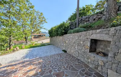a stone retaining wall with a stone fireplace at Apartment Senik in Grgar