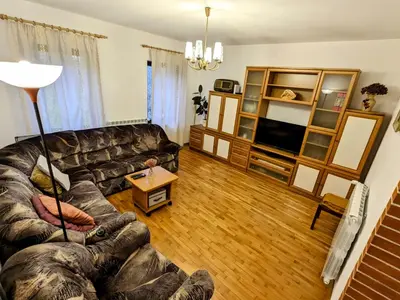 a living room with a couch and a television at Apartment Senik in Grgar