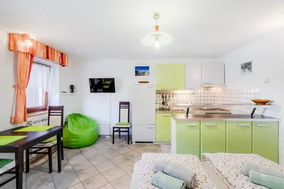 a kitchen and living room with a couch and a table at Apartma Vučič in Bovec