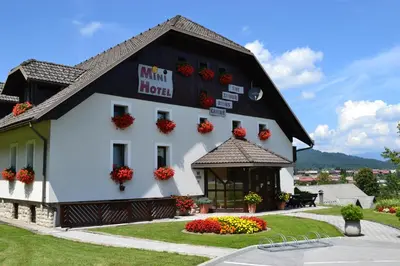 a white building with flowers in front of it at Mini Hotel in Škofja Loka