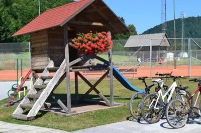 a playground with a play structure with flowers and bikes at Mini Hotel in Škofja Loka