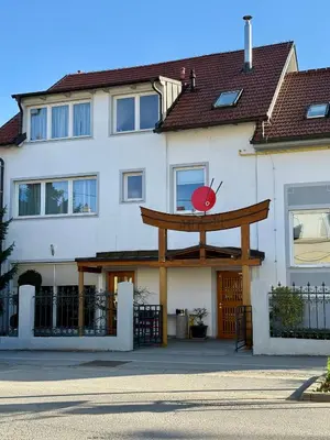a white building with a large wooden sign on it at Miyabi 1 in Maribor