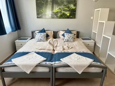 a bed with blue and white blankets and pillows on it at Miyabi 1 in Maribor