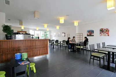 a restaurant with people sitting at tables in a room at Miyabi 1 in Maribor