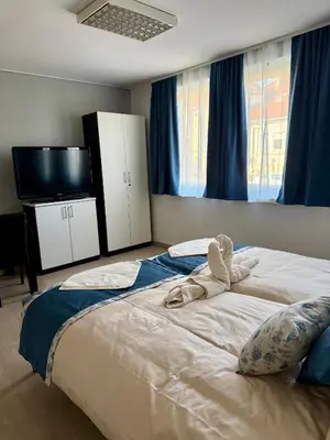 a bedroom with a large bed and a flat screen tv at Miyabi 1 in Maribor